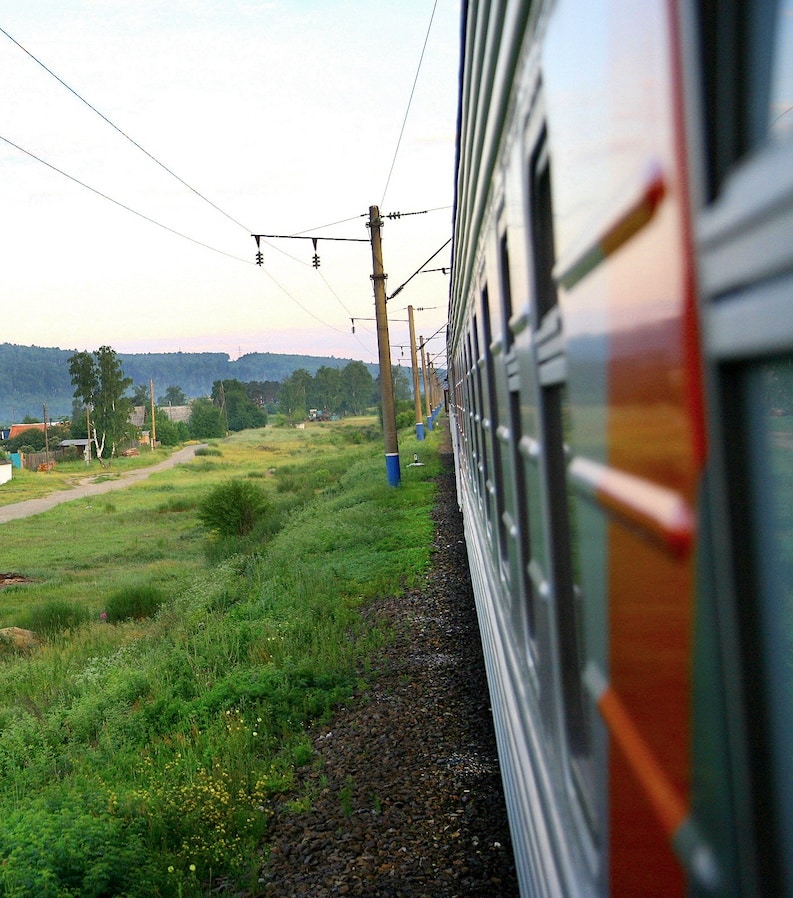 Die Transsibirische Eisenbahn während sie an einem Dorf vorbei fährt