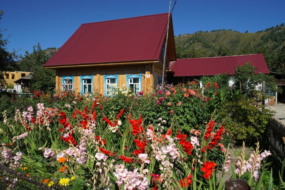 Russiches Holzhaus mit einem bunten Garten davor